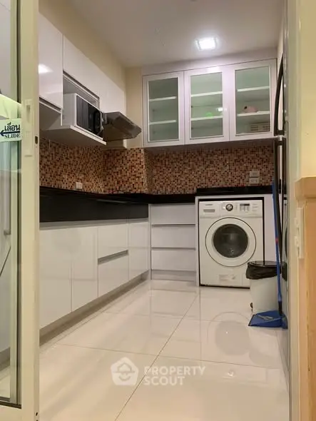 Modern kitchen with sleek cabinets and washing machine