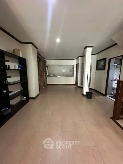 Spacious open-plan living area with tiled flooring and built-in shelving