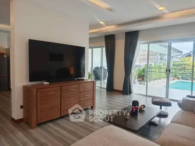 Spacious living room with modern decor and pool view, perfect for luxury living.