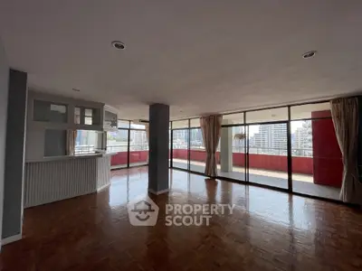 Spacious living room with large windows and city view, featuring a big balcony for outdoor enjoyment.