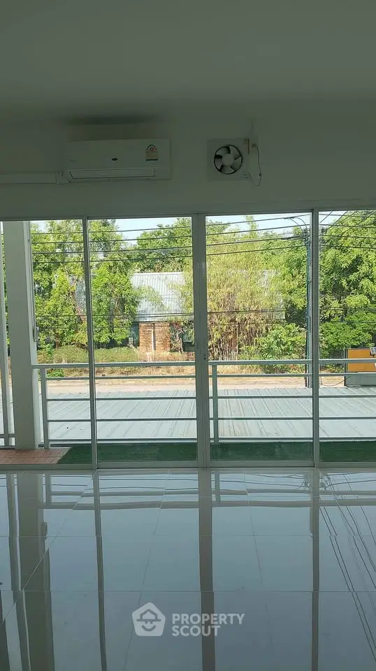 Spacious room with large windows offering a serene garden view, perfect for natural light lovers.