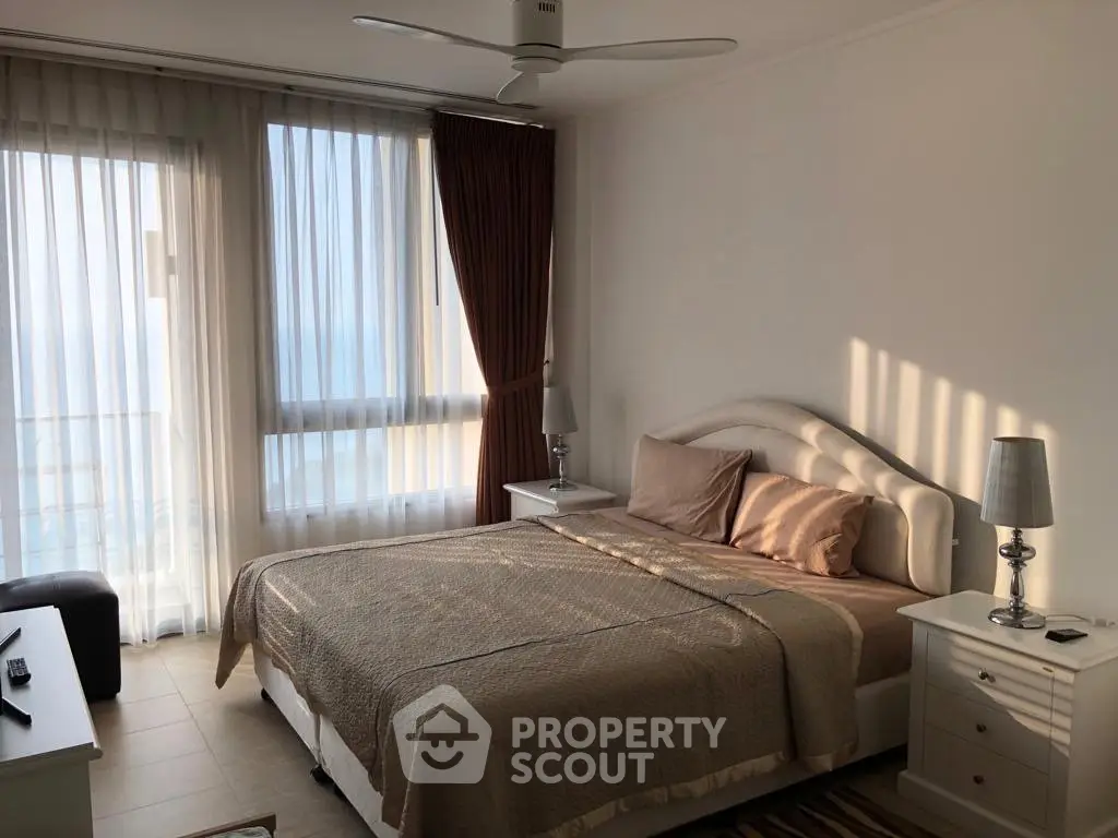 Cozy bedroom with elegant decor and natural light, featuring a comfortable bed and stylish bedside tables.