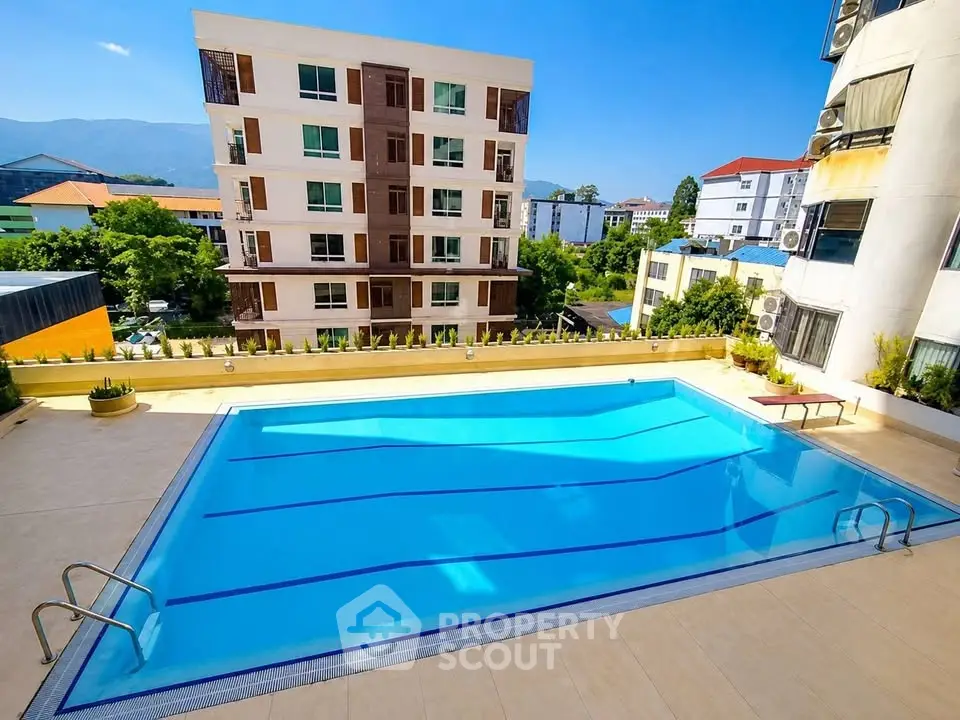 Luxurious apartment complex with a stunning outdoor pool and scenic views.
