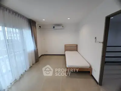 Minimalist bedroom with single bed and large window in modern apartment