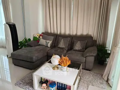 Cozy living room with plush gray sofa, stylish decor, and natural light for a welcoming ambiance.