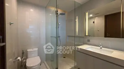 Modern bathroom with glass shower and sleek fixtures in a contemporary apartment.