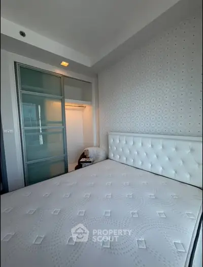 Modern bedroom with stylish wallpaper and sliding closet doors