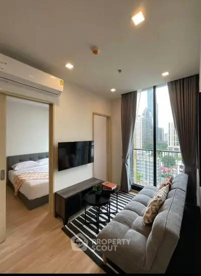 Modern living room with city view, cozy sofa, and stylish decor in urban apartment.