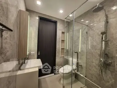 Modern bathroom with glass shower and sleek fixtures in luxury apartment