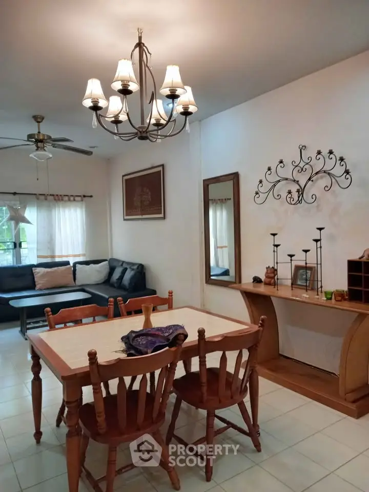 Charming living room with elegant chandelier and cozy dining area, perfect for family gatherings.