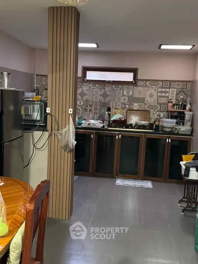 Spacious kitchen with modern appliances and stylish backsplash tiles.