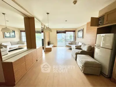 Spacious living room with modern decor and large windows offering natural light and a cozy ambiance.