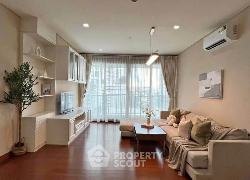 Spacious living room with modern decor and large windows in a stylish apartment.