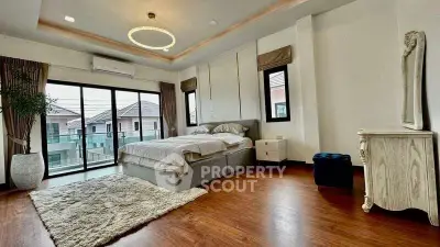 Spacious bedroom with elegant decor and large windows offering natural light.
