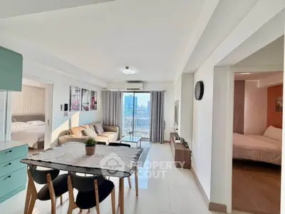 Modern open-plan living and dining area with city view, featuring stylish decor and ample natural light.