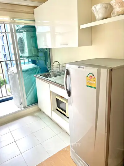 Modern kitchen with sleek appliances and balcony view, perfect for urban living.