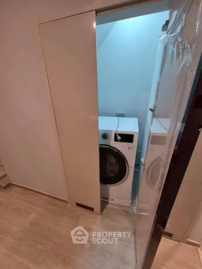 Modern laundry area with Bosch washing machine in sleek storage space.