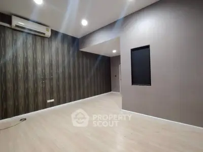 Spacious modern living room with stylish wallpaper and air conditioning unit.
