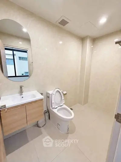 Modern bathroom with sleek fixtures and large mirror in a contemporary home.