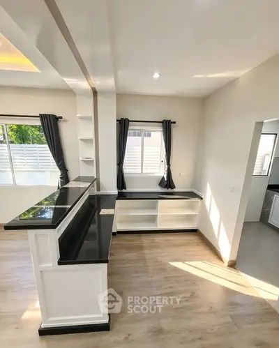 Modern living room with sleek black countertops and ample natural light