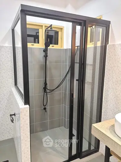 Modern bathroom with sleek glass shower enclosure and stylish fixtures.