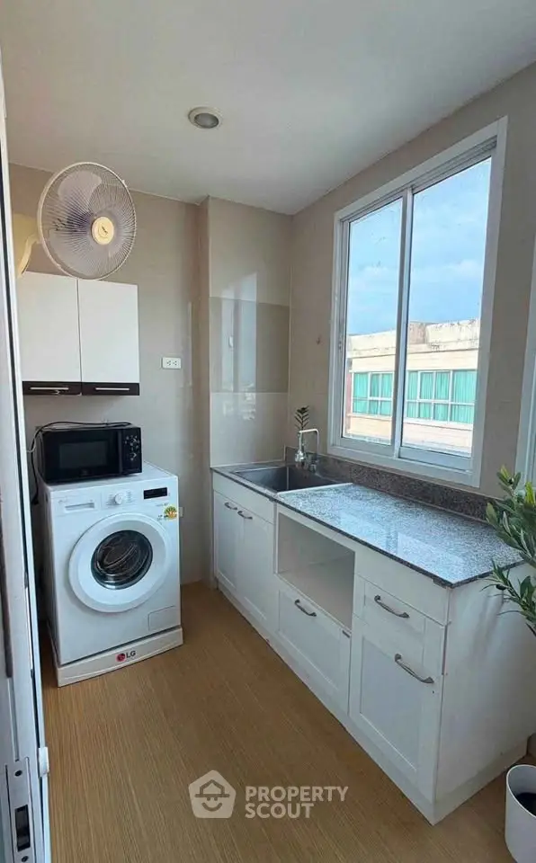 Modern kitchen with washing machine and large window view