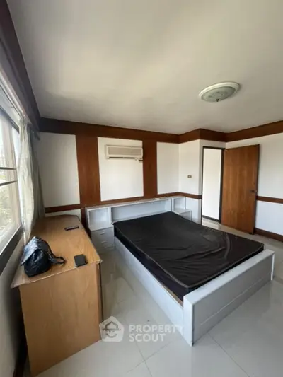 Spacious bedroom with natural light and modern furnishings