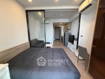 Modern studio apartment with sleek design, featuring a cozy bed, compact kitchen, and stylish furnishings.
