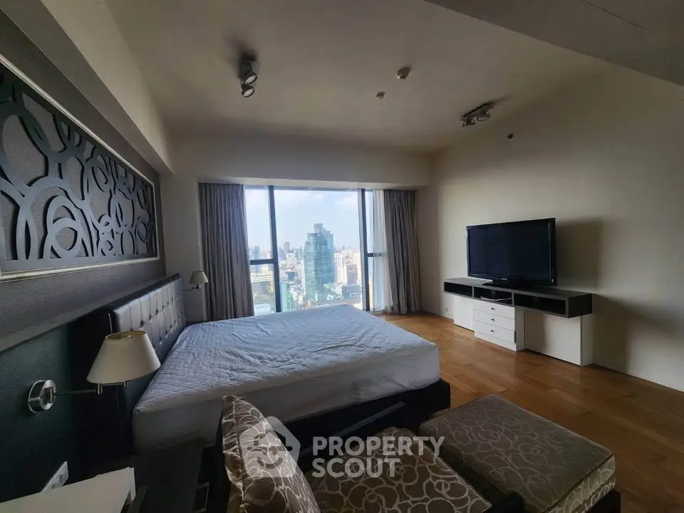 Luxurious bedroom with stunning city view, featuring modern decor and large windows for natural light.