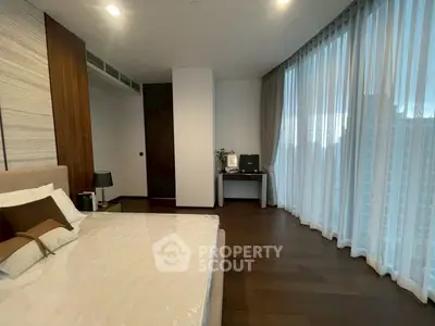 Luxurious bedroom with floor-to-ceiling windows and elegant decor in a modern apartment.