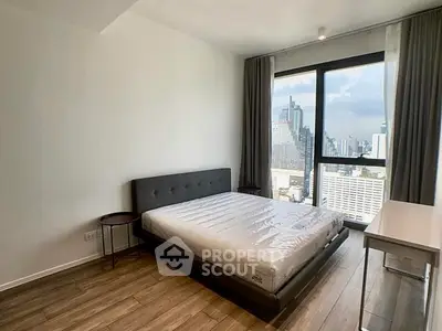 Modern bedroom with city view, featuring sleek design and large window for natural light.
