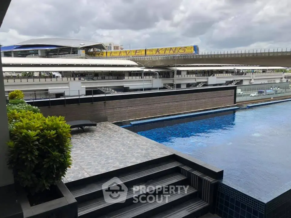 Luxurious poolside view with modern architecture and urban backdrop, perfect for relaxation and leisure.