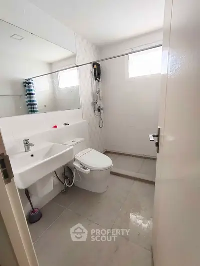 Modern bathroom with sleek fixtures and spacious shower area.