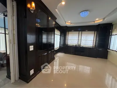 Spacious room with elegant dark wood cabinetry and modern lighting