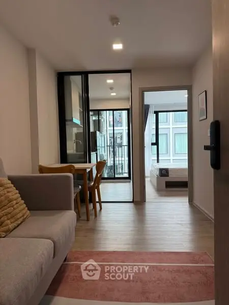 Modern apartment interior with open layout, featuring cozy living area and bedroom view.