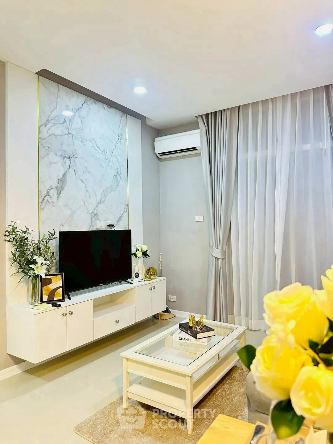 Elegant living room with modern decor, marble accent wall, and cozy ambiance.