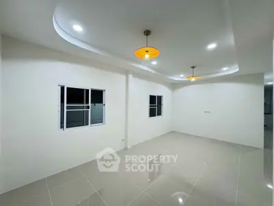 Spacious modern living room with elegant lighting and tiled flooring