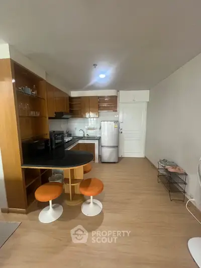 Modern kitchen with open layout and stylish bar stools in a cozy apartment.