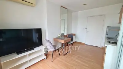 Modern living room with TV, dining table, and air conditioning in a cozy apartment.