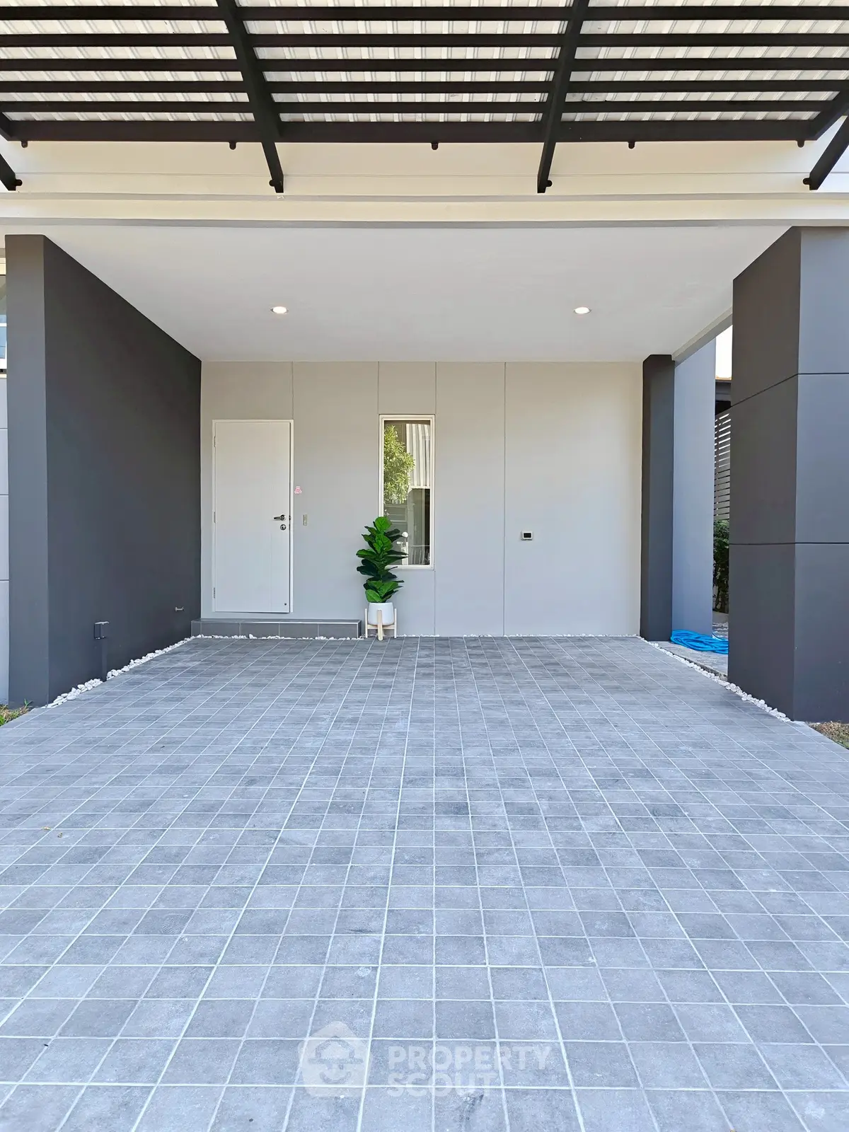 Modern home entrance with sleek design and spacious tiled driveway