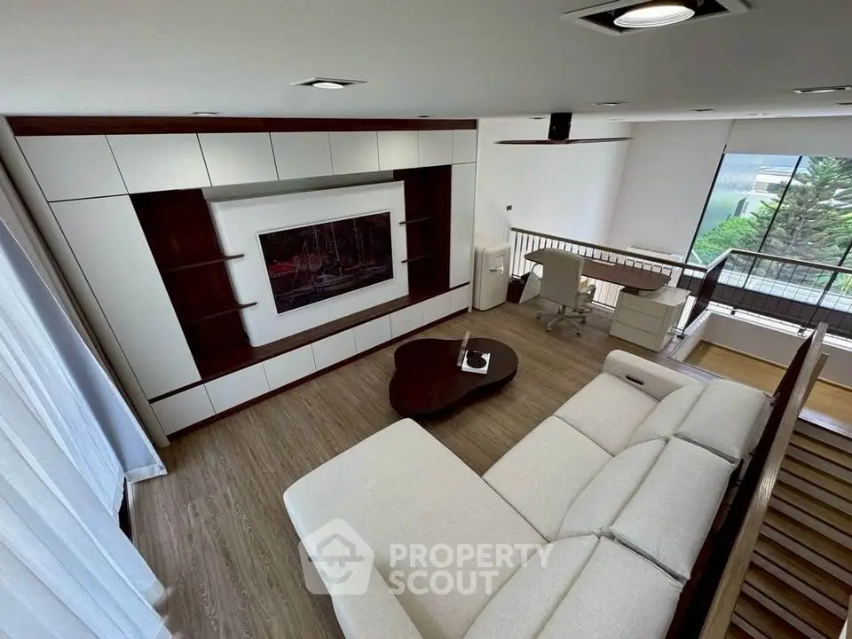 Spacious modern living room with elegant decor and large windows offering natural light.
