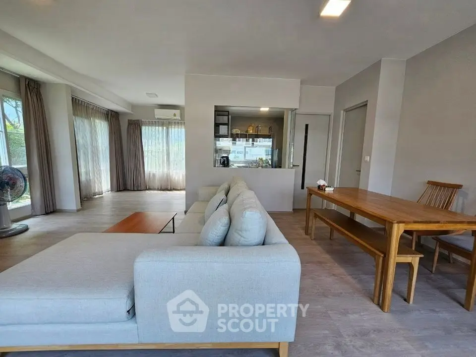 Spacious modern living room with large windows and elegant furniture