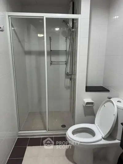 Modern bathroom with glass shower and sleek white tiles