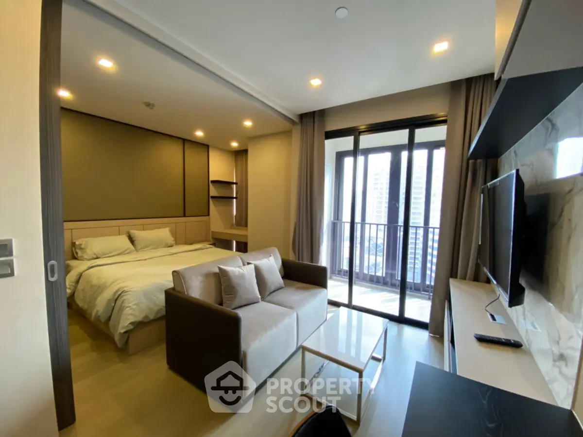 Modern studio apartment with cozy living area and balcony view