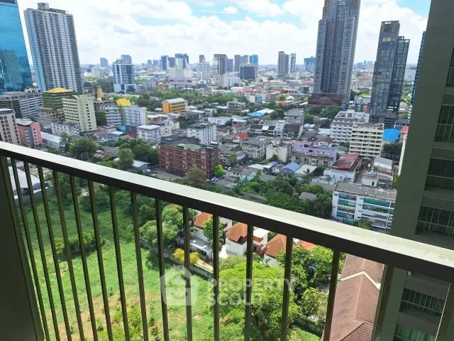 Stunning cityscape view from a high-rise balcony overlooking urban skyline and greenery.