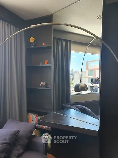 Modern living room with stylish bookshelf and city view, perfect for urban living.