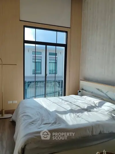 Bright bedroom with large window and modern decor