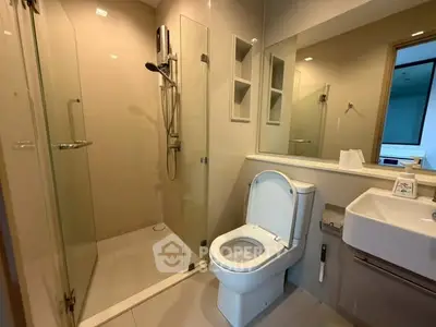 Modern bathroom with glass shower and sleek fixtures in a contemporary apartment.
