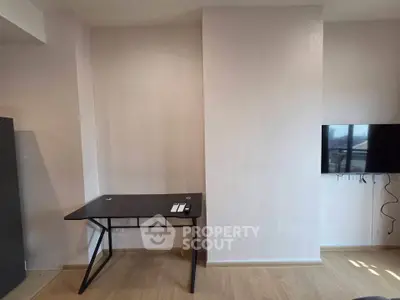 Modern minimalist study area with sleek desk and wall-mounted TV in a contemporary apartment.