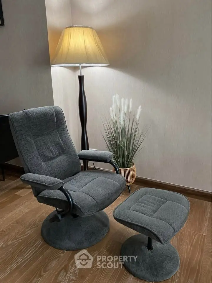 Cozy corner with plush armchair and matching footrest, perfect for relaxation.